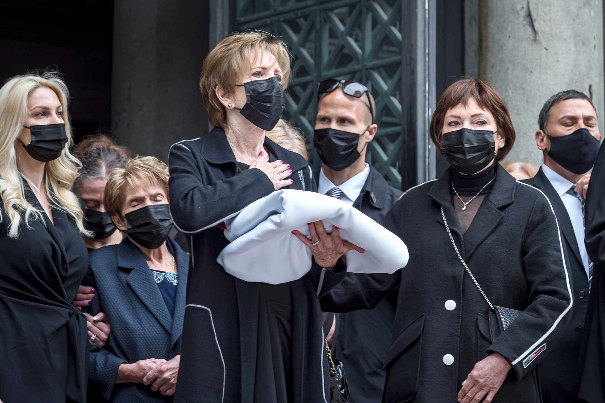 Lise Lafleur, la femme de Guy, tient la bannière avec le logo du Canadien de Montréal qui drapait le cercueil, à la sortie du cortège, mardi à la cathédrale Marie-Reine-du-Monde, à Montréal. Elle est entourée par sa belle-fille Angelica Lafleur, la mère de Guy Lafleur, Pierette, ainsi que sa sœur Francine Barré.
